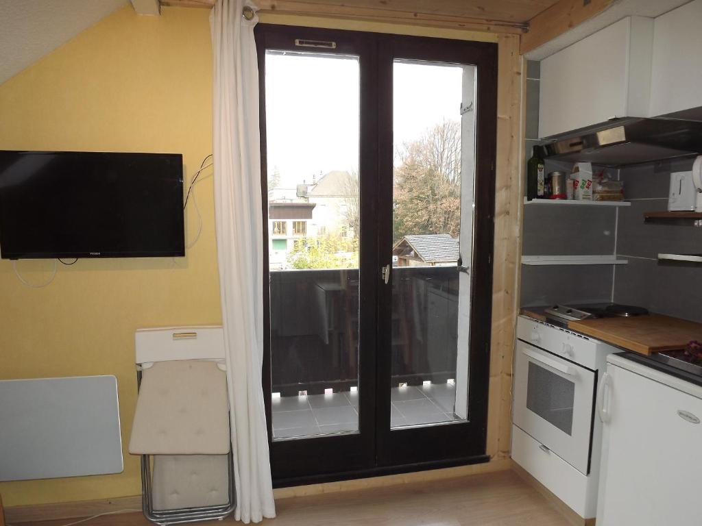 ル・ブール・ドアザンにあるStudio La Muzelle Bourg d'Oisansのガラスの引き戸(窓付)が備わるキッチン