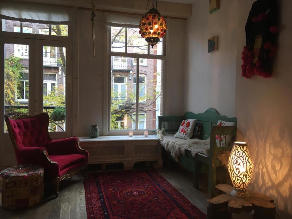 a living room with a couch and a window at Bohemian loft in Amsterdam