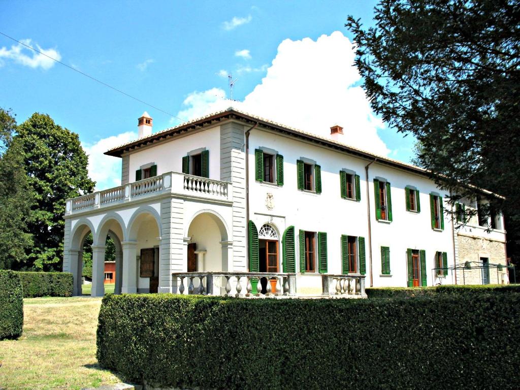 una gran casa blanca con persianas verdes en Villa Martina, en Molezzano