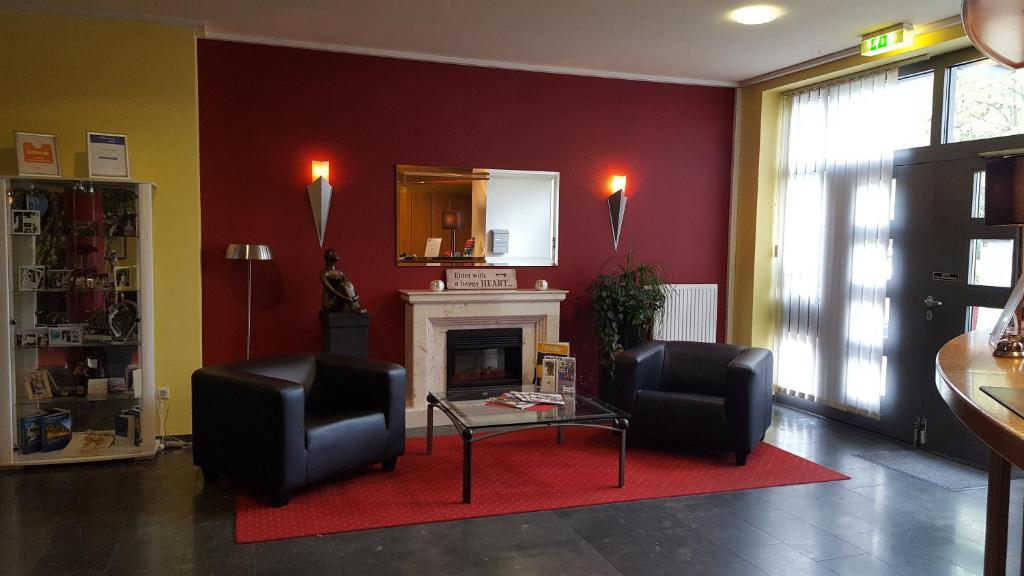 a living room with two chairs and a fireplace at Hotel Sternzeit in Wegberg