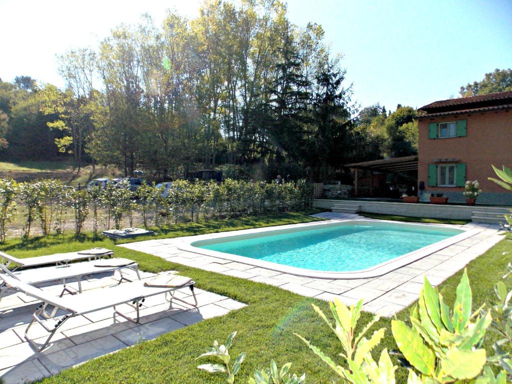 - une piscine dans une cour avec 2 chaises et une maison dans l'établissement Casa Marcoiano, à Marcoiano