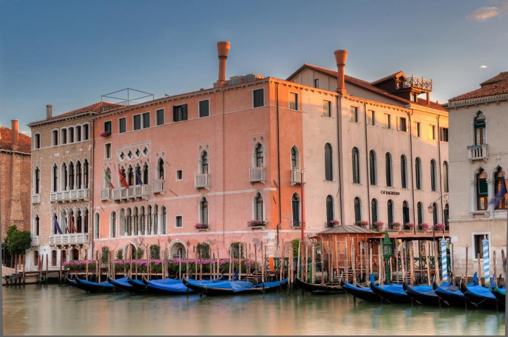 un grupo de góndolas en el agua frente a los edificios en Ca' Sagredo Hotel en Venecia