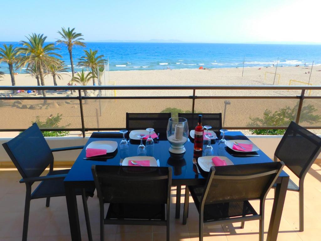 una mesa azul y sillas en un balcón con vistas a la playa en GMID IMMO Apartamento Oasis, en Roses