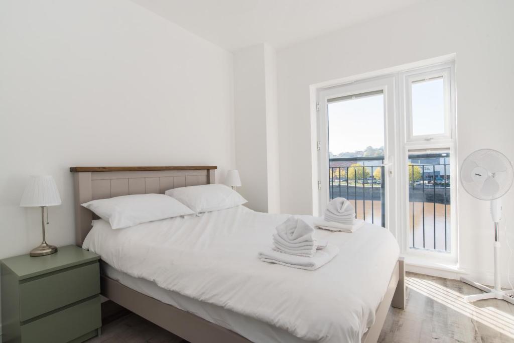 a white bedroom with a bed and a window at Raphael Heights in Newport