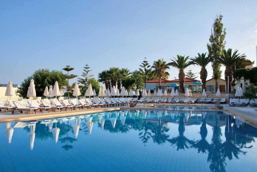 uma grande piscina com cadeiras e guarda-sóis em Rethymno Mare & Water Park em Skaleta