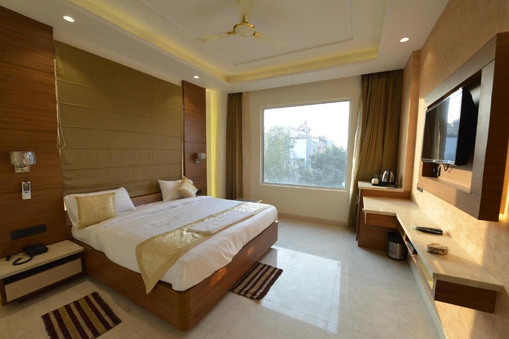 1 dormitorio con 1 cama grande y TV en Hotel RR 62, en Jaipur