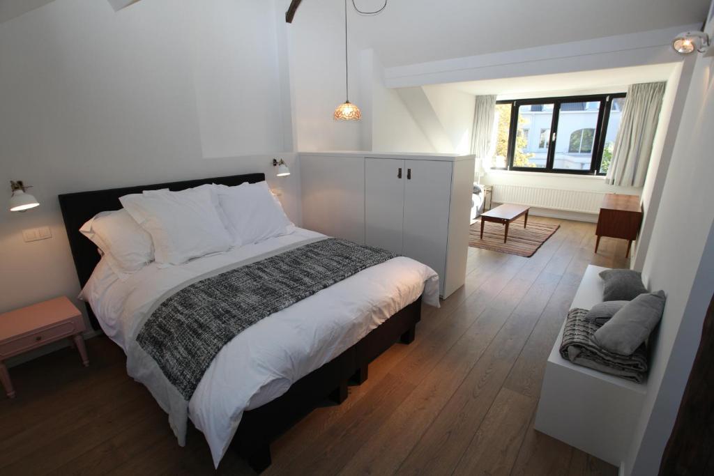 a bedroom with a large bed and a living room at Coeur Sablon in Brussels