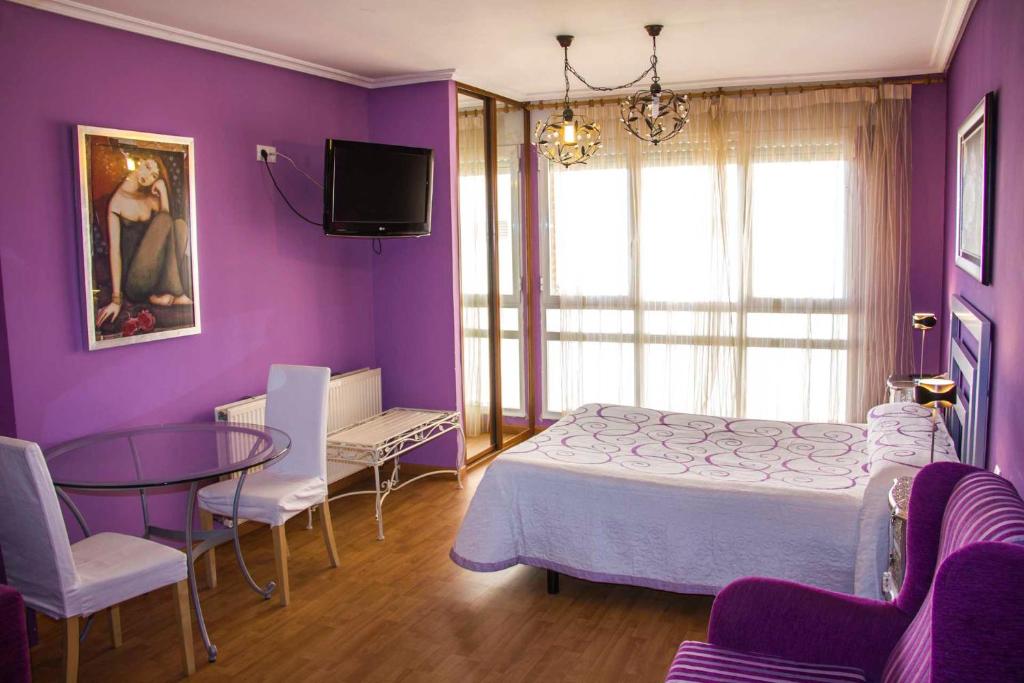 Dormitorio púrpura con cama, mesa y sillas en Gala II, en Soria