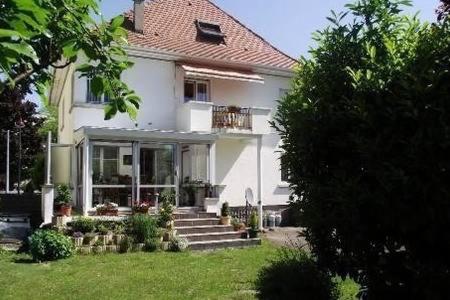 een wit huis met een veranda en een trap in een tuin bij BEL APPARTEMENT LUMINEUX in Colmar