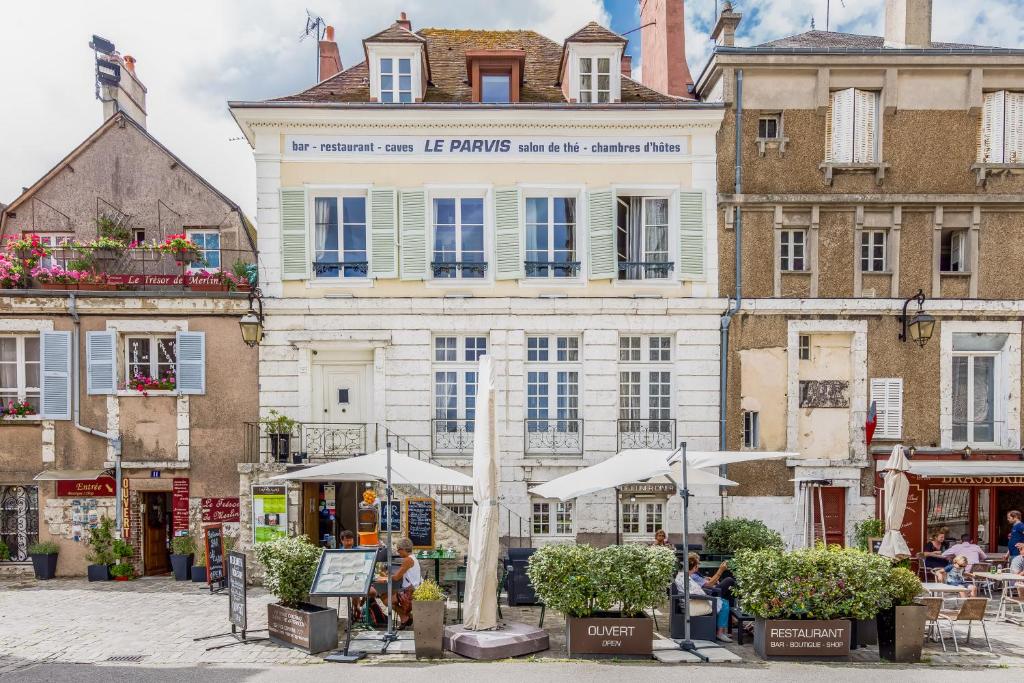 Un grand bâtiment blanc avec des personnes debout devant lui dans l'établissement Le Parvis, à Chartres