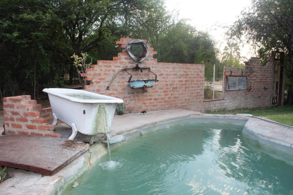 a bath tub sitting next to a brick wall at Roy's Rest Camp in Groutfontein
