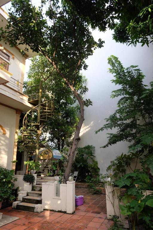 un edificio con scale e un albero di fronte ad esso di Moon house tropical garden - Valentine a Nha Trang