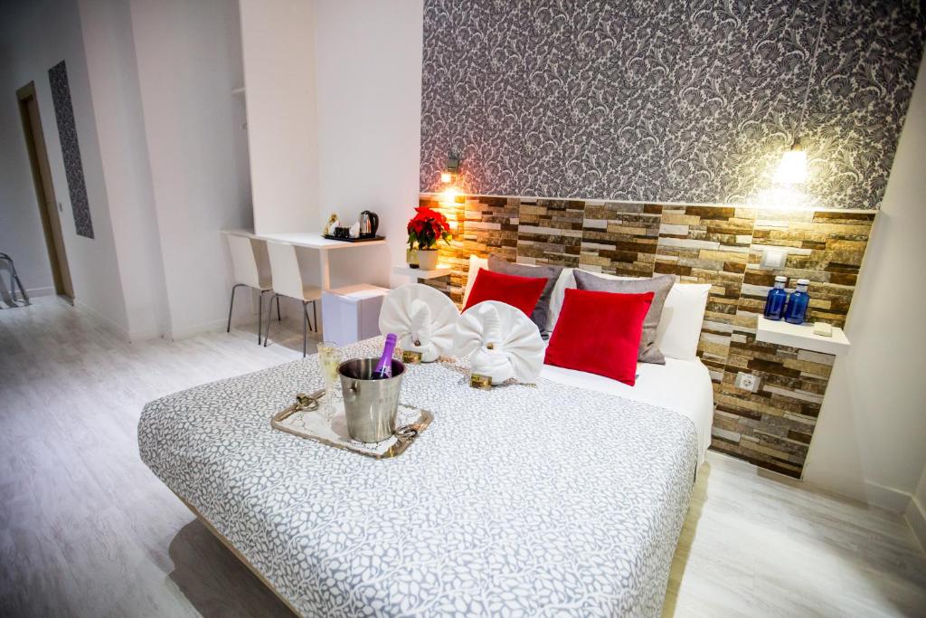 een slaapkamer met een groot bed met rode kussens bij Hostal Adis in Madrid