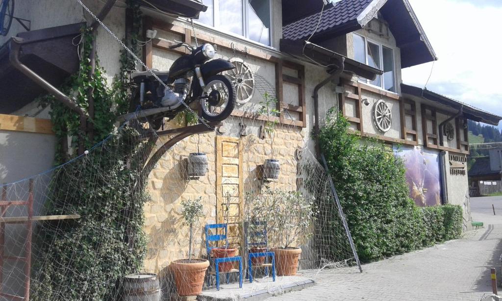 a motorcycle hanging off the side of a building at Pensiunea TOTAL din Ceahlău in Ceahlău