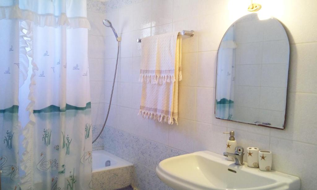 biała łazienka z umywalką i lustrem w obiekcie Villa the Platanus Tree w mieście Káto Vasilikí