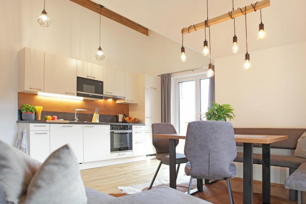 a kitchen and living room with a table and chairs at Appartementhaus Sky Lodge in Altenmarkt im Pongau