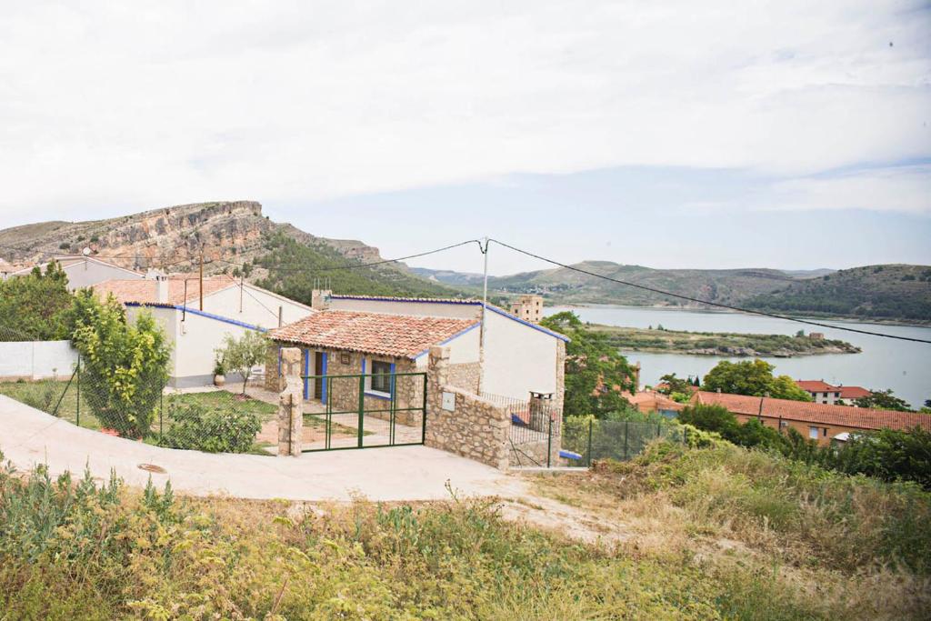 uma casa numa colina com vista para uma massa de água em Casa rural la Era del Malaño em Nuévalos