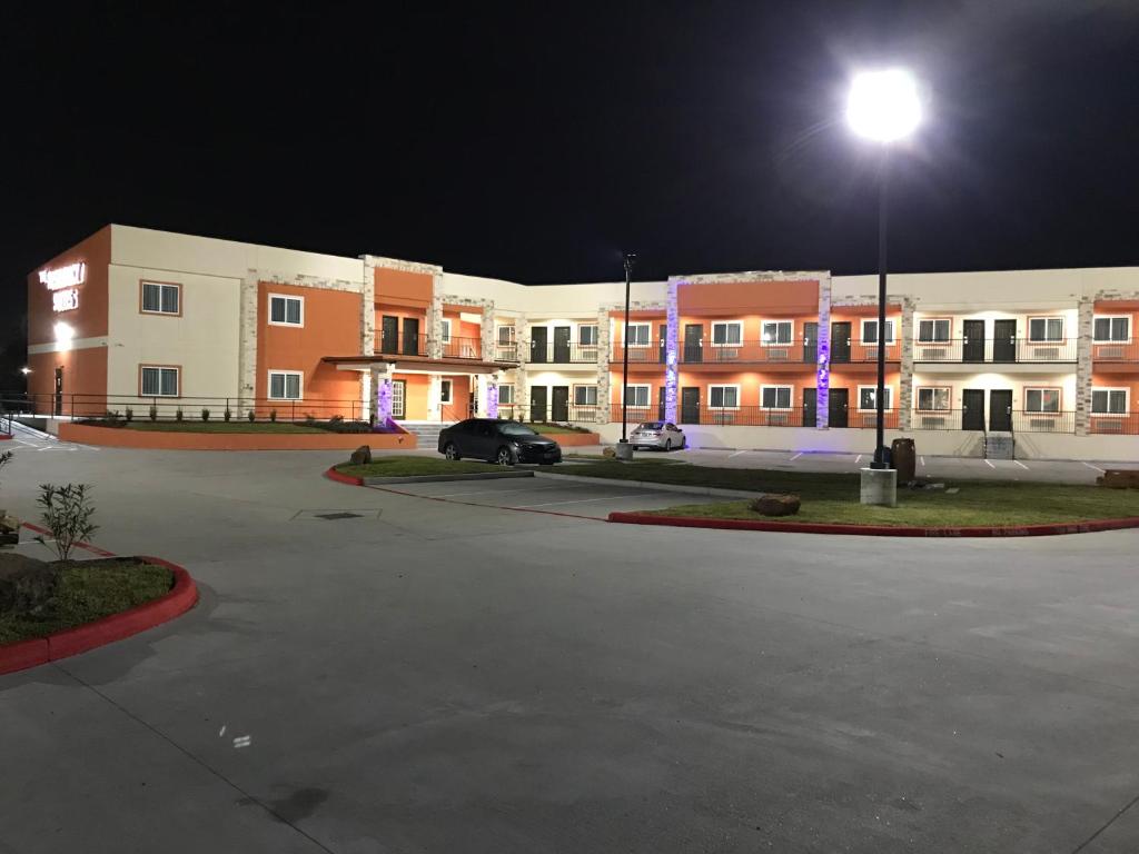 a parking lot in front of a building at night at The Residency Suites in Houston