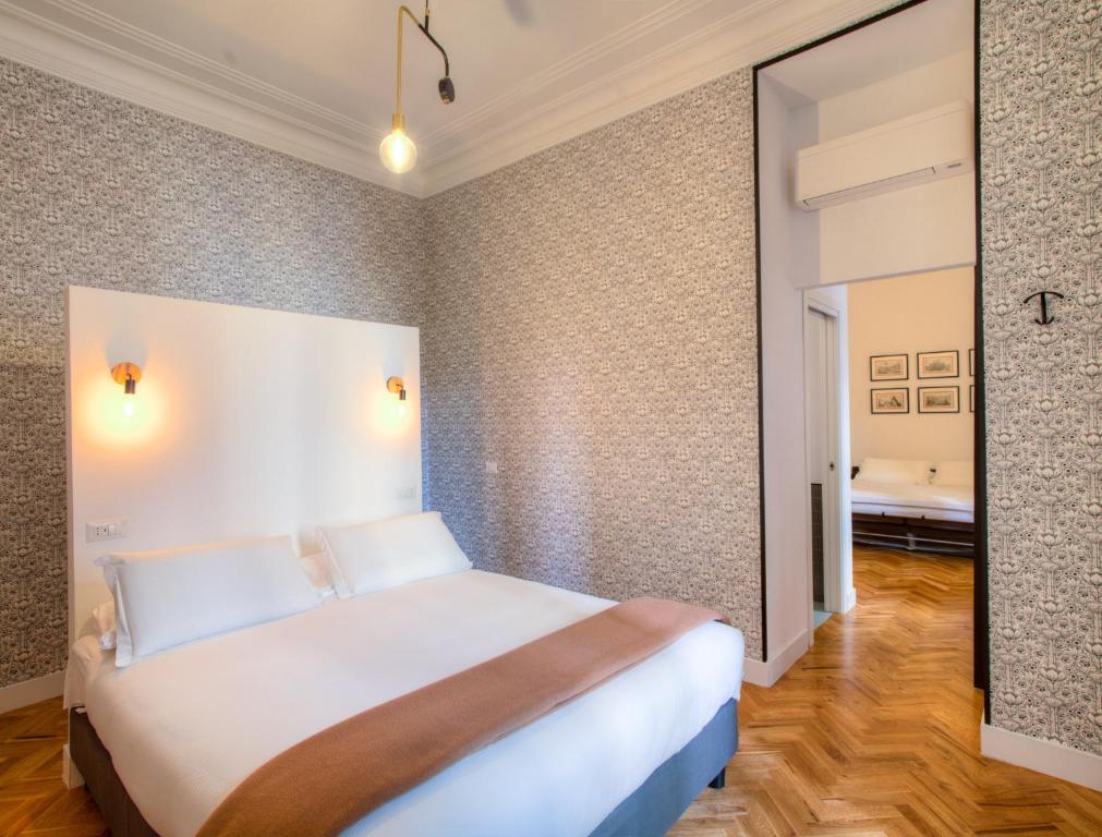 a bedroom with a large white bed and a mirror at App Beccaria Apartments in Rome in Rome