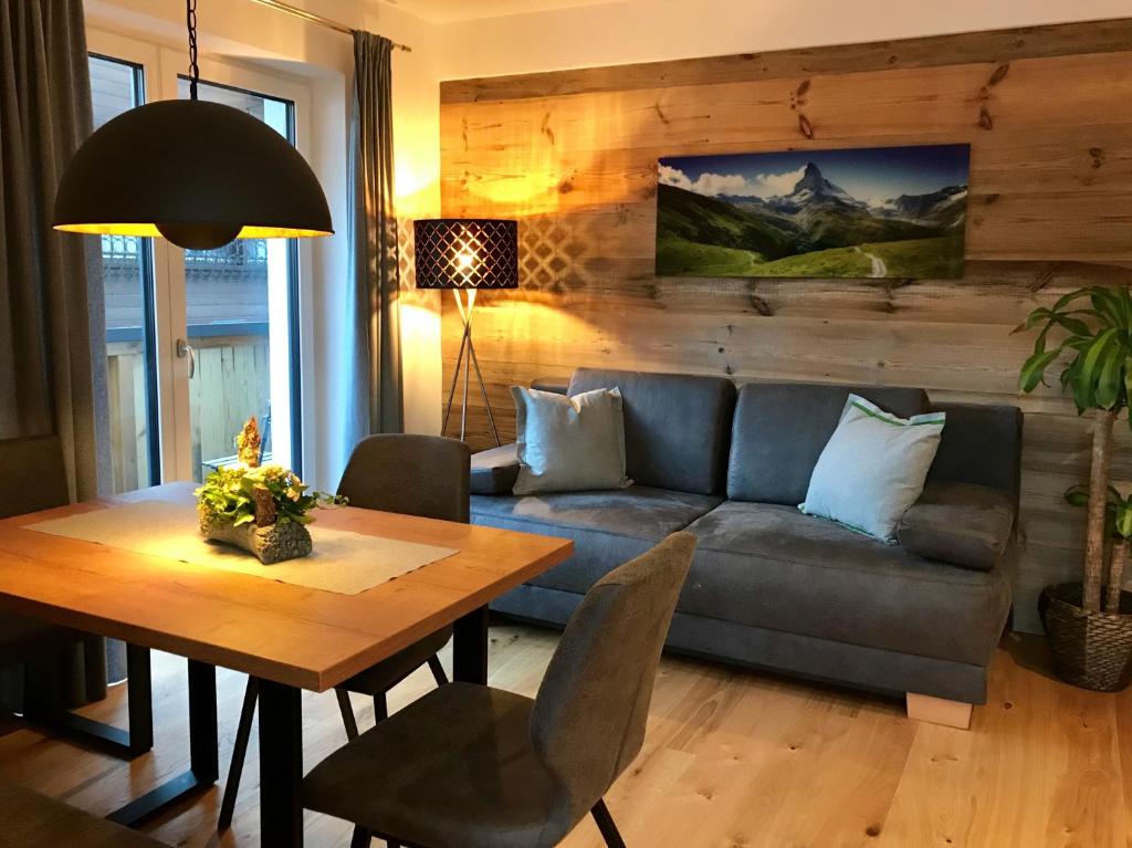 ein Wohnzimmer mit einem Sofa und einem Tisch in der Unterkunft Appartementhaus Mountain Room in Altenmarkt im Pongau