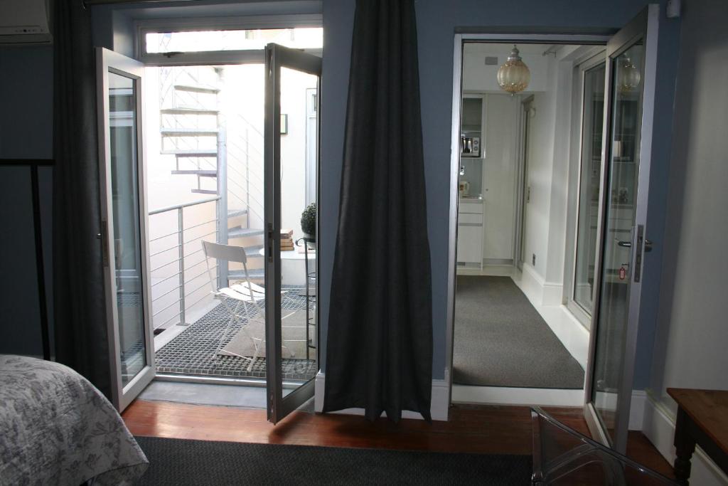 a bedroom with a mirror and a door to a balcony at Wild Artz in Cape Town