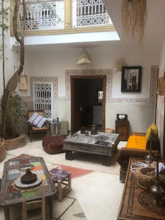 una sala de estar con sofás y mesas. en Riad Dar Zioui, en Marrakech