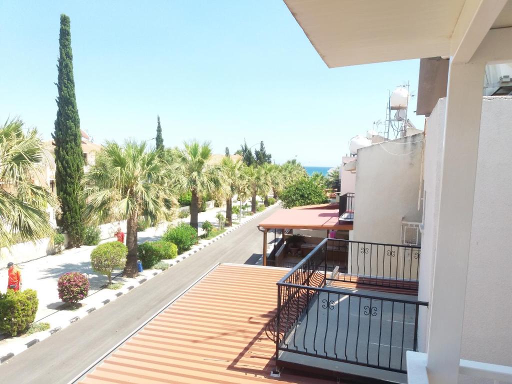 een balkon van een huis met palmbomen bij Pirgos beach house in Larnaka