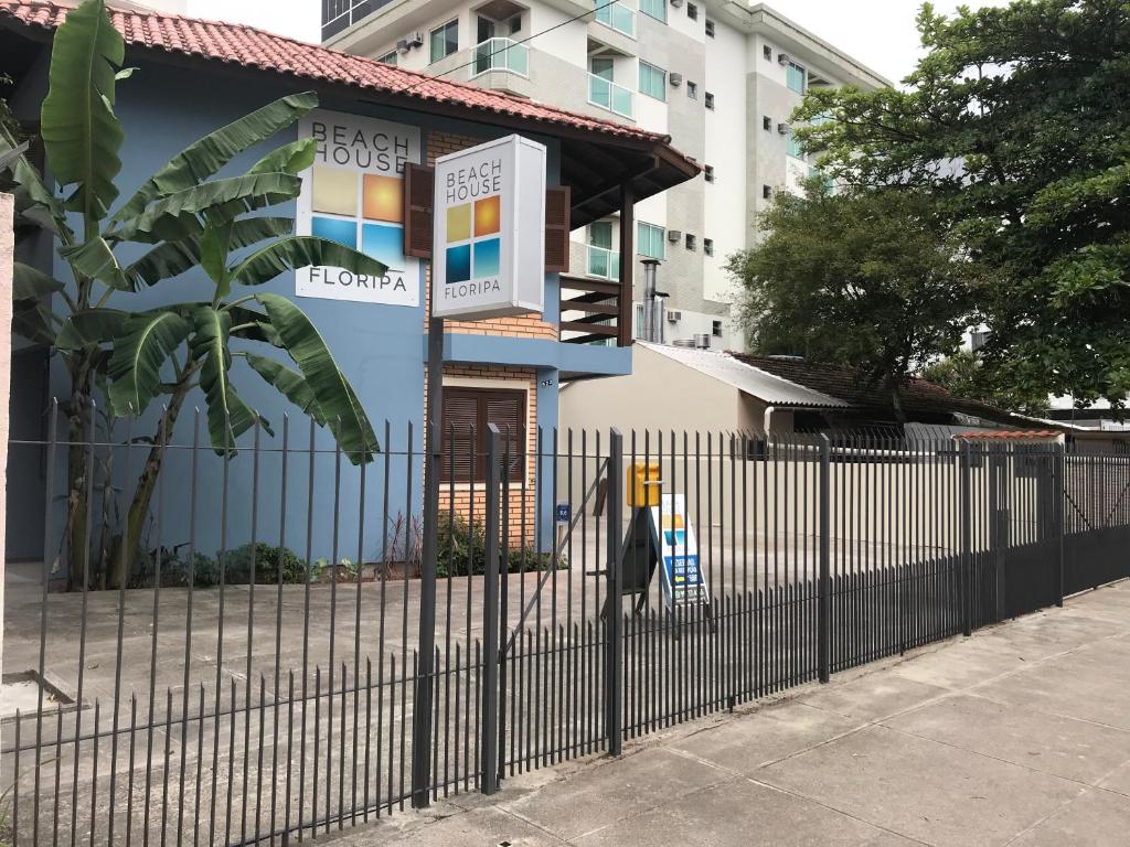 una valla frente a un edificio azul en Beach House Floripa - Sunset, en Florianópolis