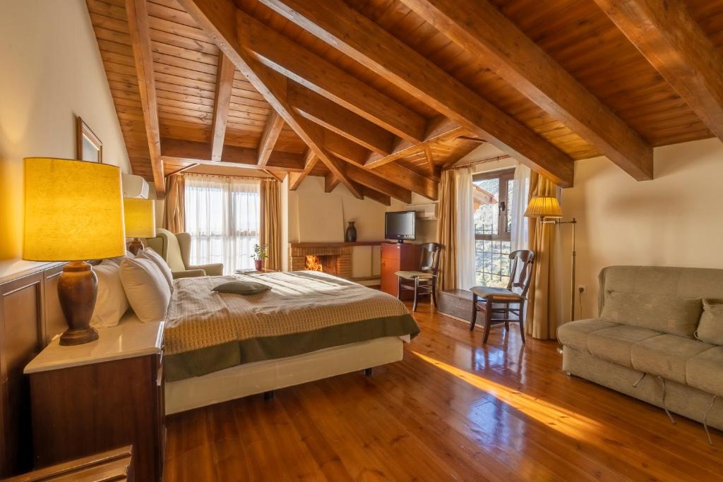 a bedroom with a bed and a couch and wooden ceilings at Domotel Anemolia Mountain Resort in Arachova