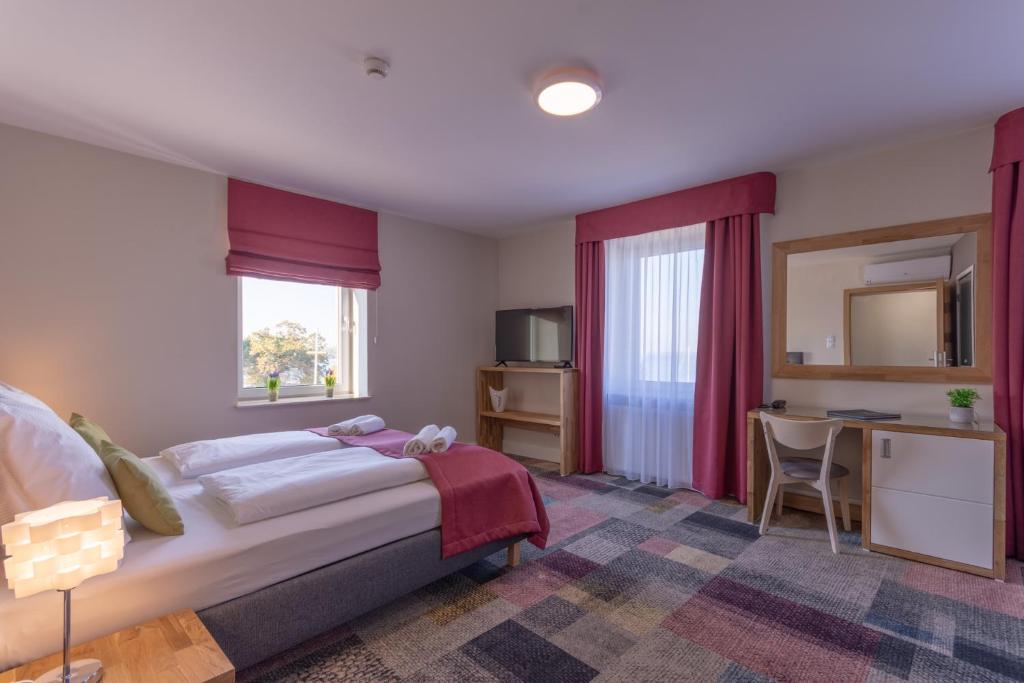 a bedroom with a bed and a desk and a kitchen at Marina Pallatium Premium Floor in Kamień Pomorski