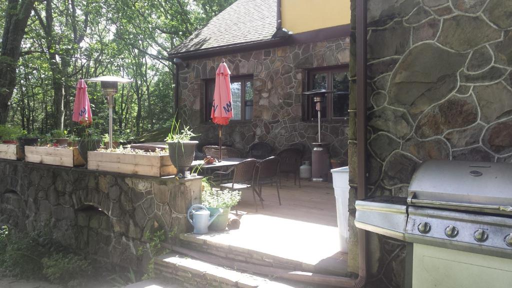 un patio esterno con griglia e un edificio in pietra di Maurrocks - A Pocono Mountains B&B a Mount Pocono