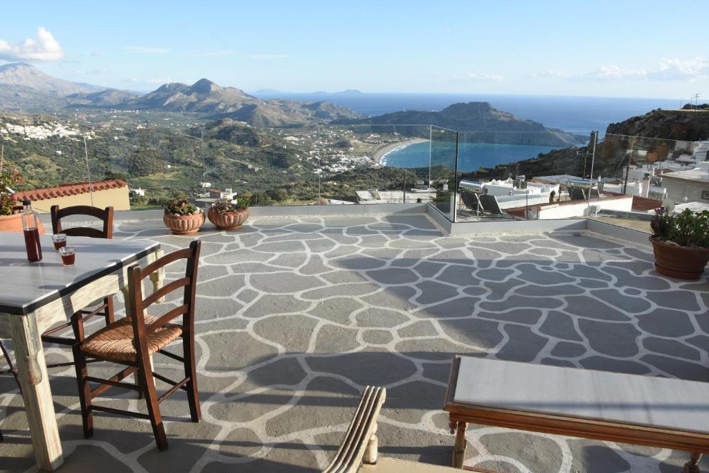 un patio con mesa, sillas y el océano en Art and Nature Apartment en Sellía