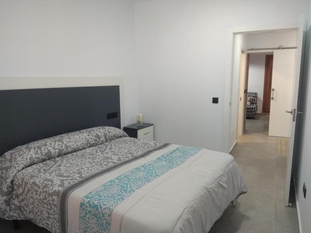 - une chambre avec un lit et une porte menant à un couloir dans l'établissement Caleros 8 Apartamento - Apartamentos de la Parte Antigua de Cáceres, à Cáceres