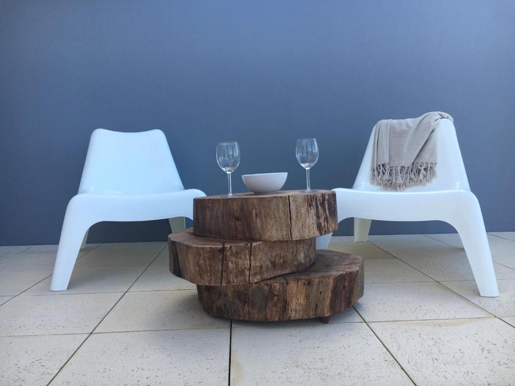 佩尼謝的住宿－Alto Mar Apartment，两把白色椅子和一张桌子,上面放着酒杯