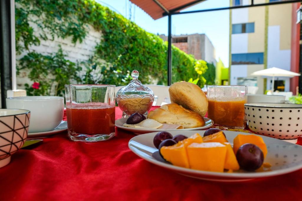 una mesa con un plato de comida y dos vasos de zumo en Casa Baraquel, en Arequipa