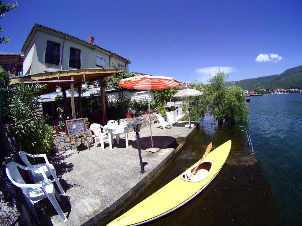 a yellow kayak sitting in the water next to a house at 'By the Lake' Apartments in Ohrid