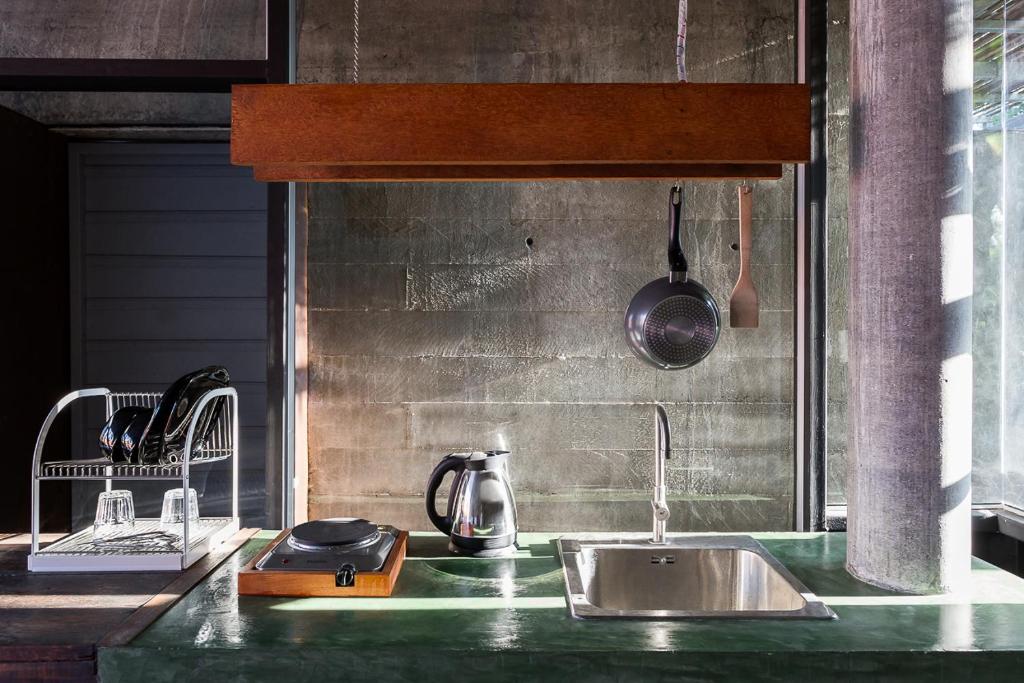 um balcão de cozinha com um lavatório e um vaso em Coconutnoom Ko Phangan em Thongsala