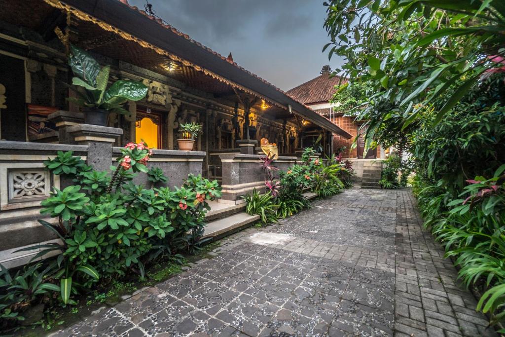 einen Steinweg vor einem Gebäude mit Pflanzen in der Unterkunft Tegar Guest House Ubud in Ubud