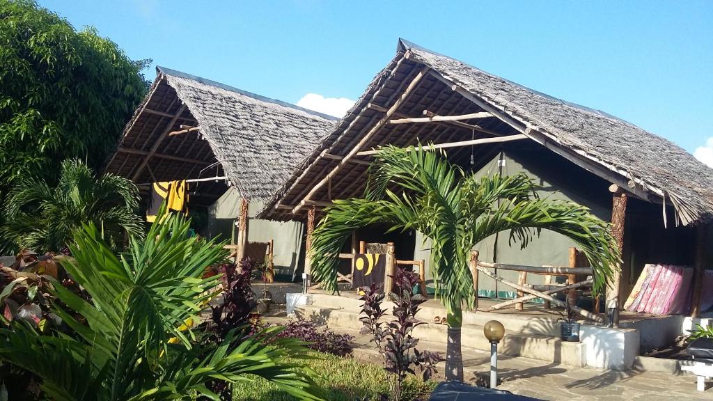 una casa con techo de gambrel y algunas plantas en Rocks villa homestay, en Galu