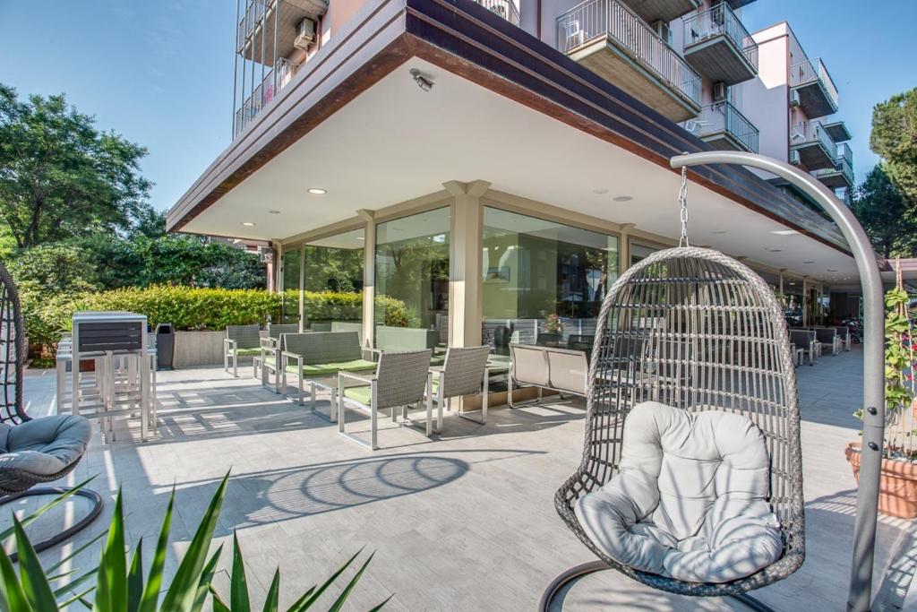 a swing on a patio next to a building at Hotel Riz in Cervia