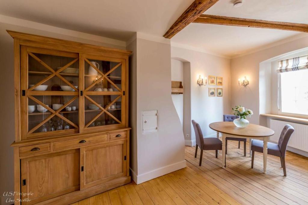 a dining room with a wooden cabinet and a table at Apartment Lindenplatz in Langenburg