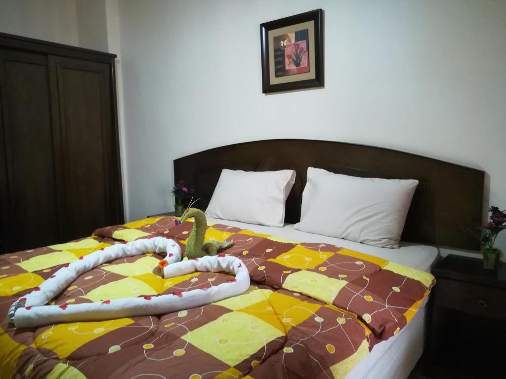 Una cama con un edredón con un cactus. en Baraka Al Aqaba Hotel Suites, en Áqaba