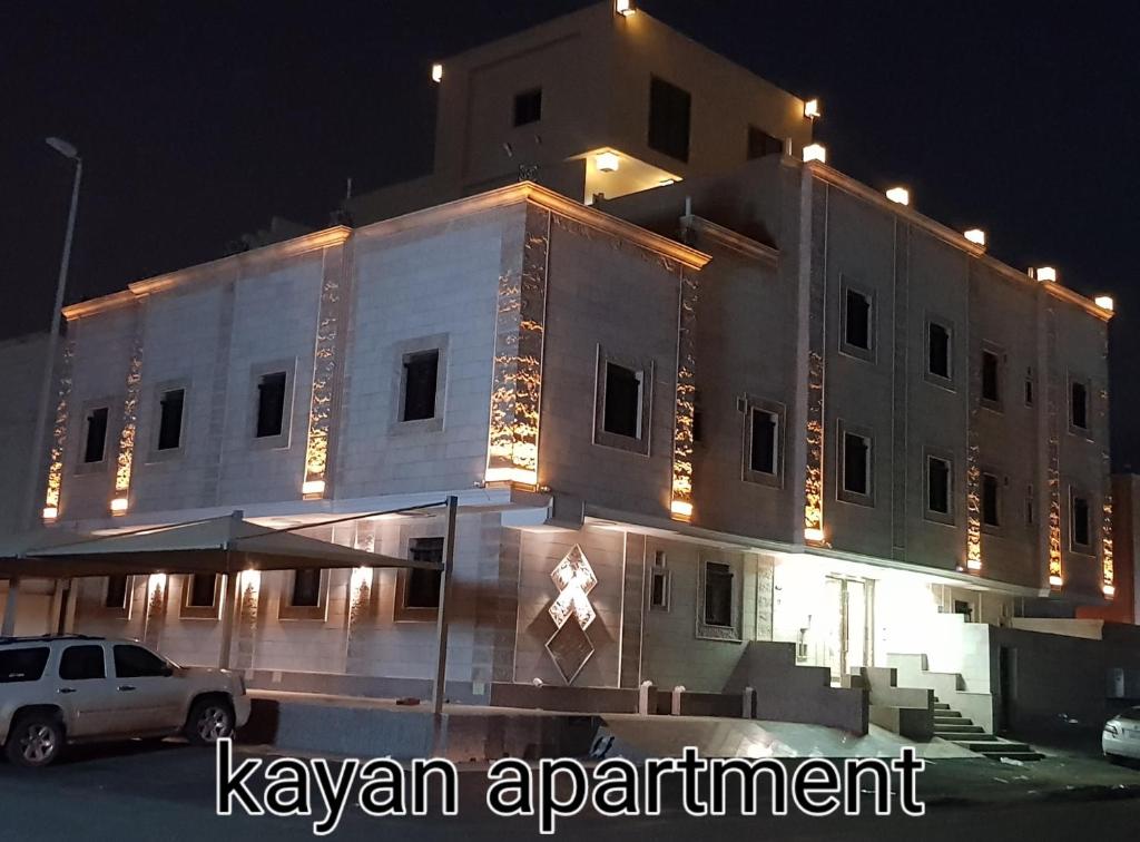 a large white building with lights on it at night at Kayan Apartments in Jeddah
