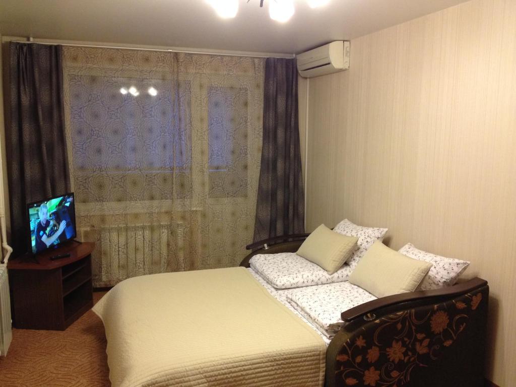 - une chambre avec un lit et une télévision dans l'établissement Apartment on Bazhenova, à Joukovski