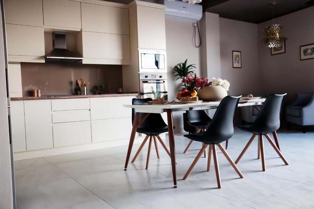 a kitchen with a table and black chairs at Rubio Residence - Frateria Apartment in Arad