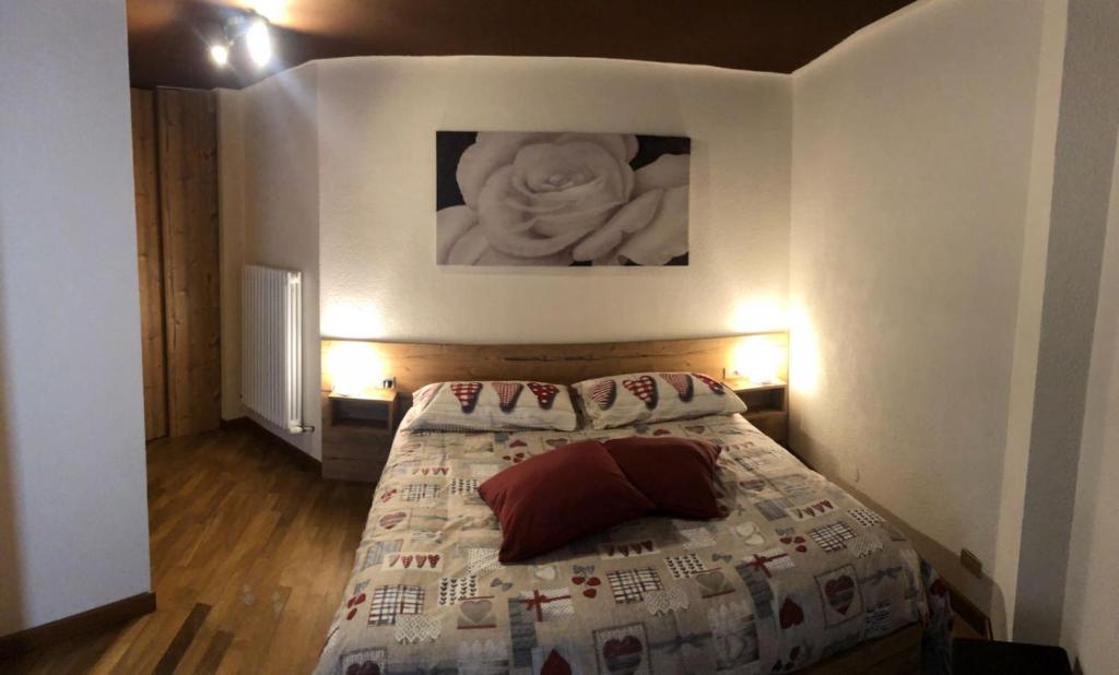 een slaapkamer met een bed met een standbeeld aan de muur bij Ski Paradise in Breuil-Cervinia