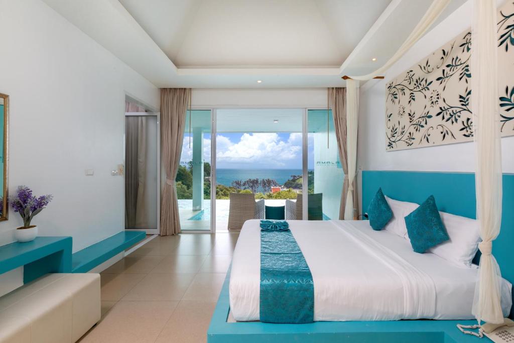 Amala Grand Bleu Resort Hilltops - SHA في شاطئ كامالا: غرفة نوم مع سرير وإطلالة على المحيط