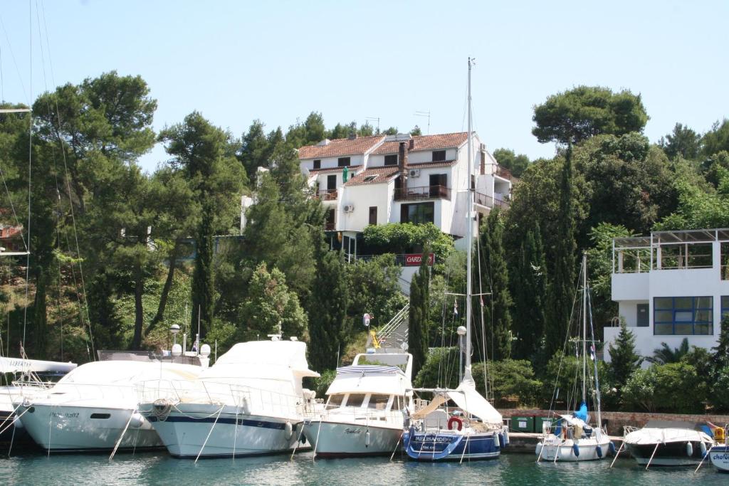 a group of boats docked in a harbor with a house at Ivanka Apartments in Vrboska