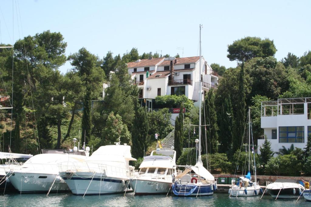 un grupo de barcos atracados en un puerto con una casa en Ivanka Apartments, en Vrboska