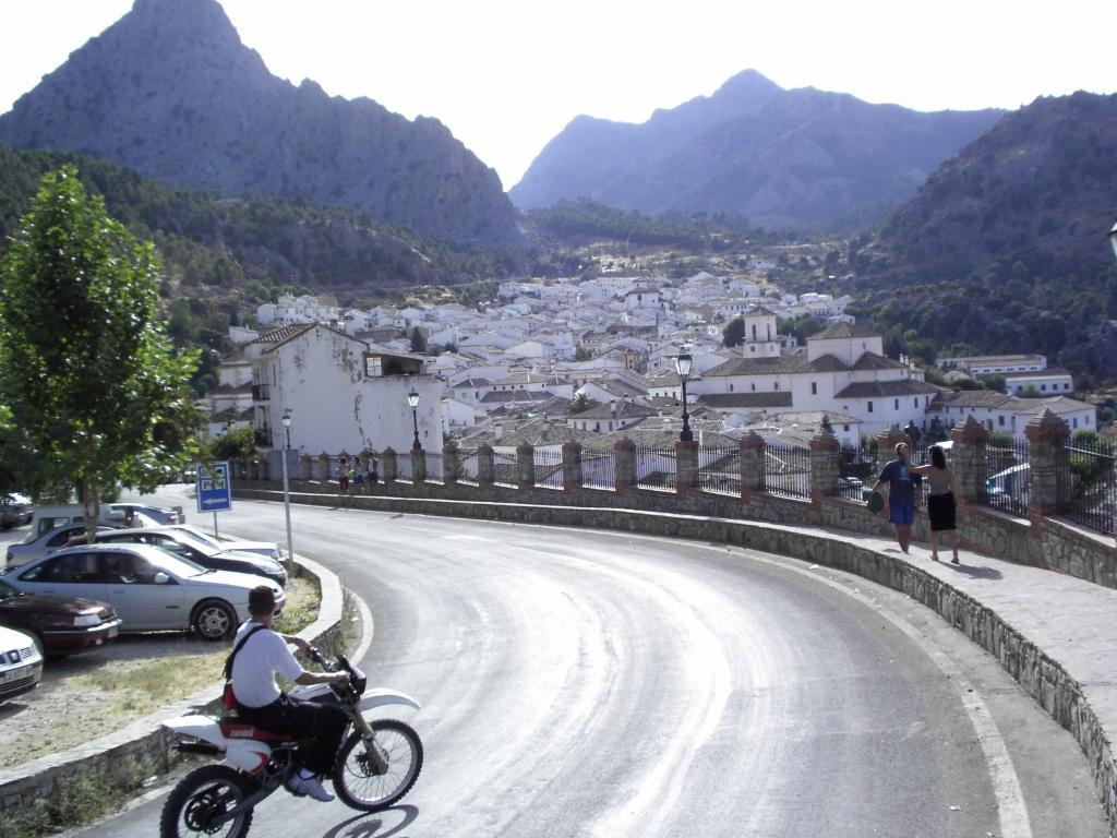 a man riding a motorcycle down a winding road at Casas Corrales in Grazalema